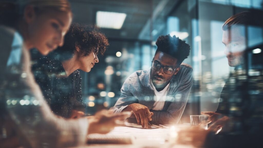 Insurance professionals collaborating in a modern office, reviewing specialty insurance solutions and client strategy.