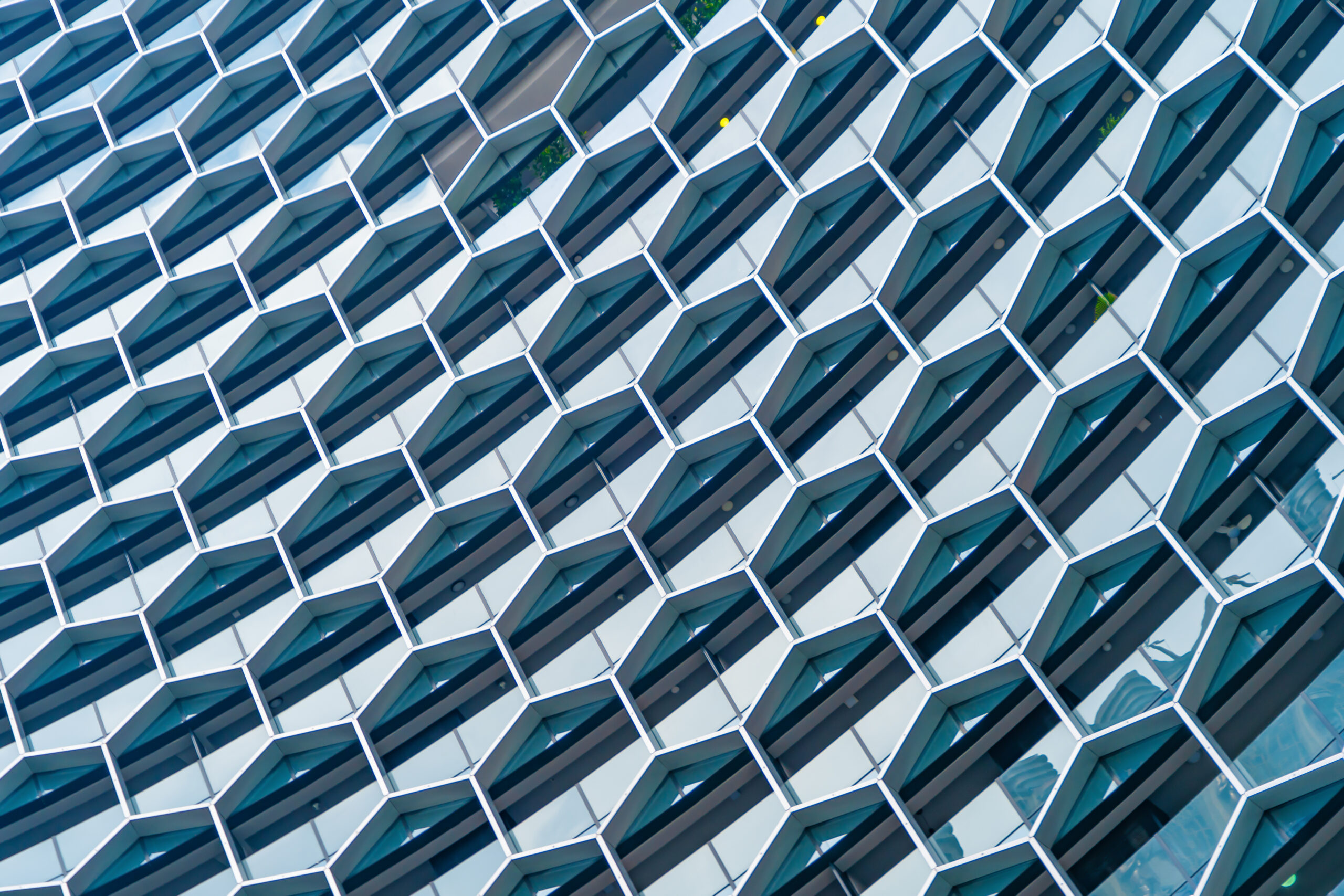 Office buildings Structure of hexagon windows in futuristic technology network connection concept Blue glass modern architecture facade design with reflection of sky in urban city Downtown - IC Group - IC Group Q2 Results image